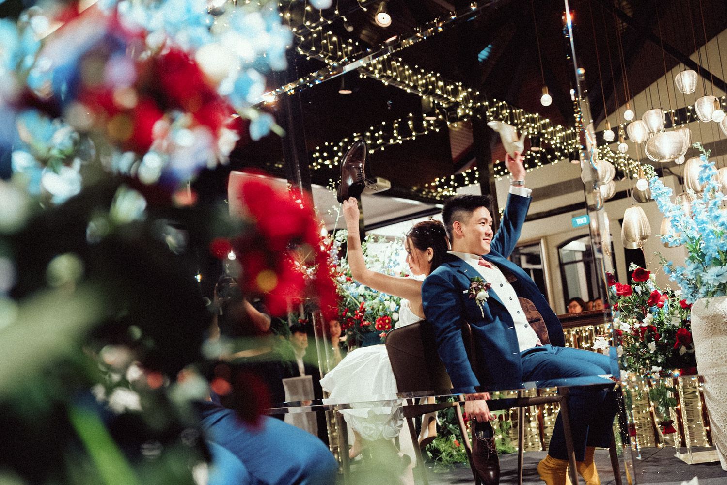Festive outdoor venue with string lights and red and blue floral decorations creating a romantic ambiance.