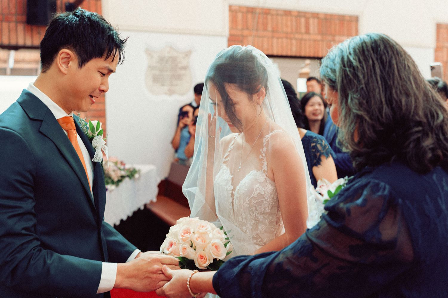 Wedding ceremony taking place in a traditional brick church with elegant decor.