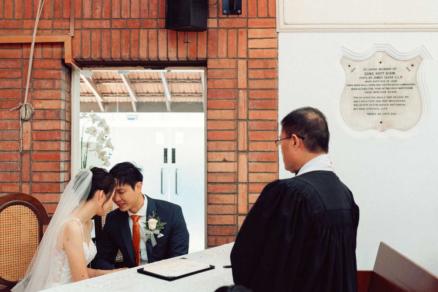 Series of wedding ceremony moments showing couple signing documents at church altar.