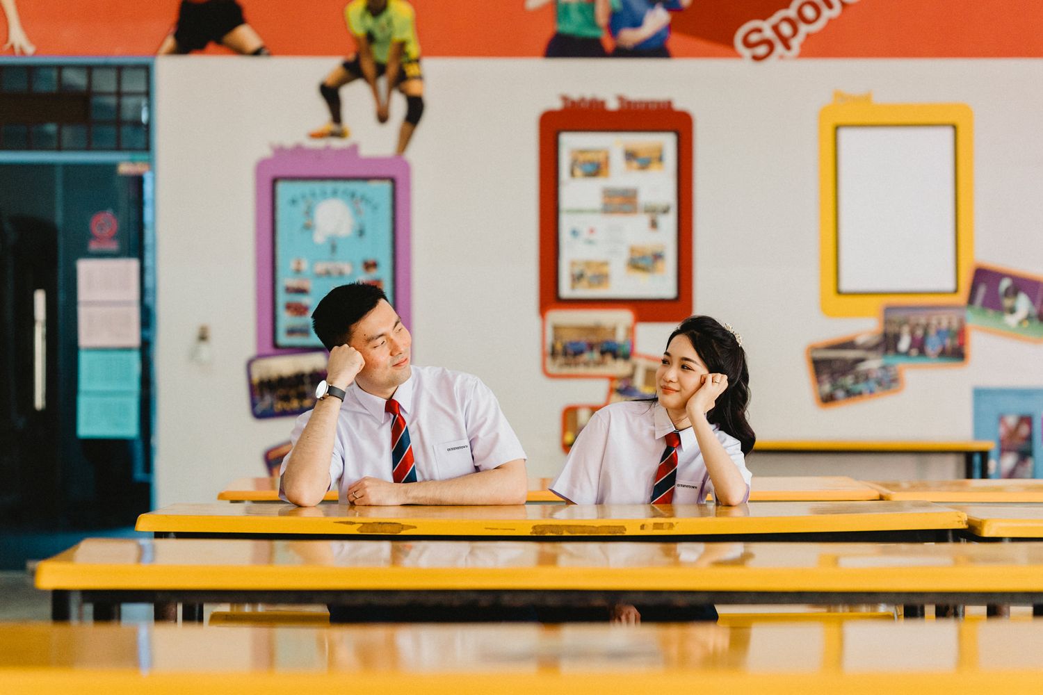 Students interacting in a school hallway with colorful bulletin boards and displays.