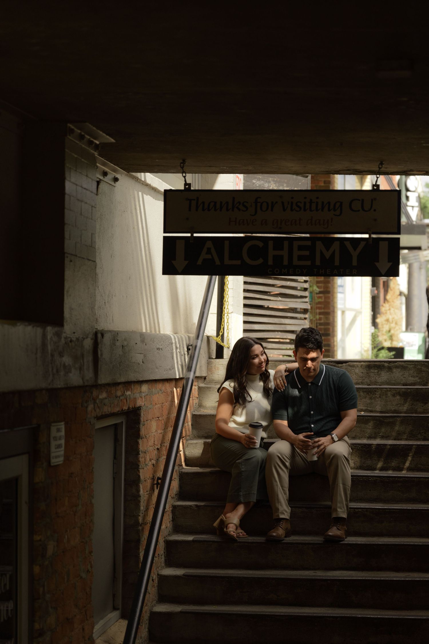A moody scene in a dark stairwell with an 'Alchemy' sign visible.