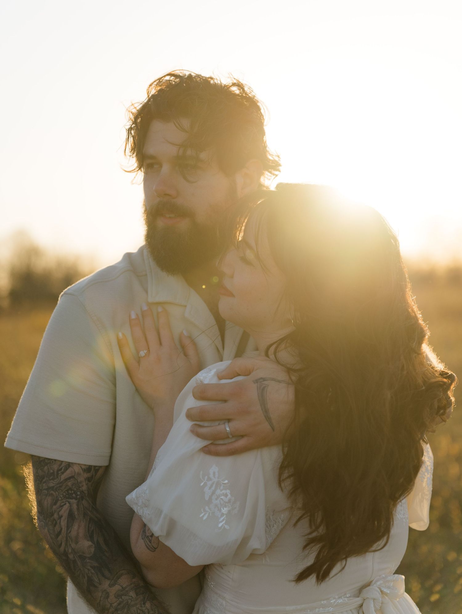 A tender embrace captured during golden hour in a sunlit outdoor setting.
