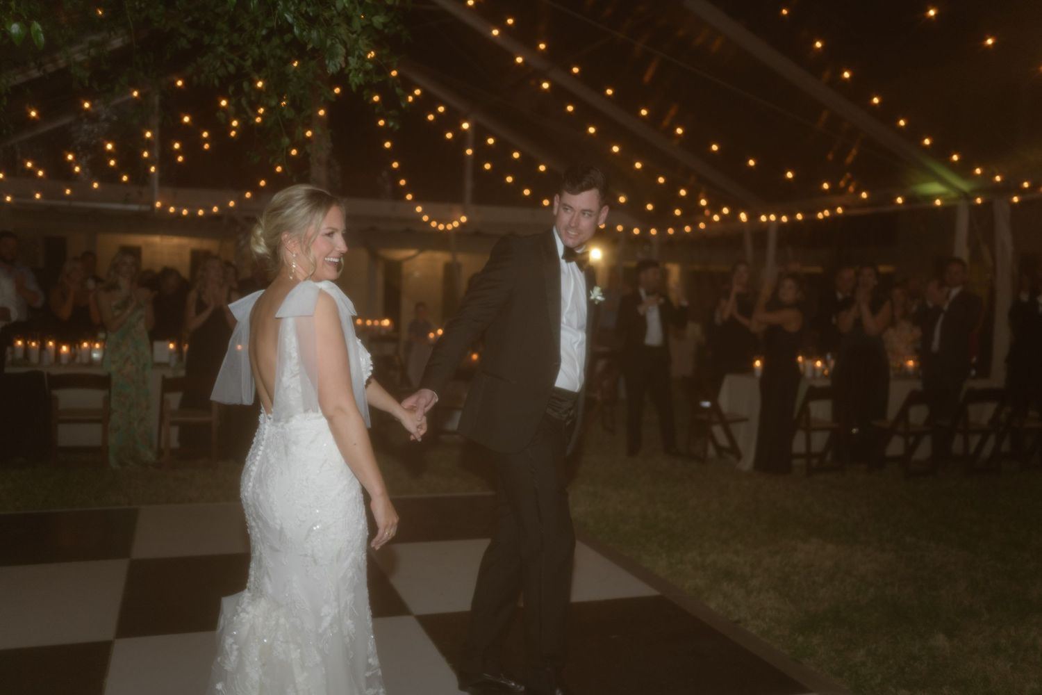 A nighttime outdoor reception with twinkling string lights creating a magical atmosphere.