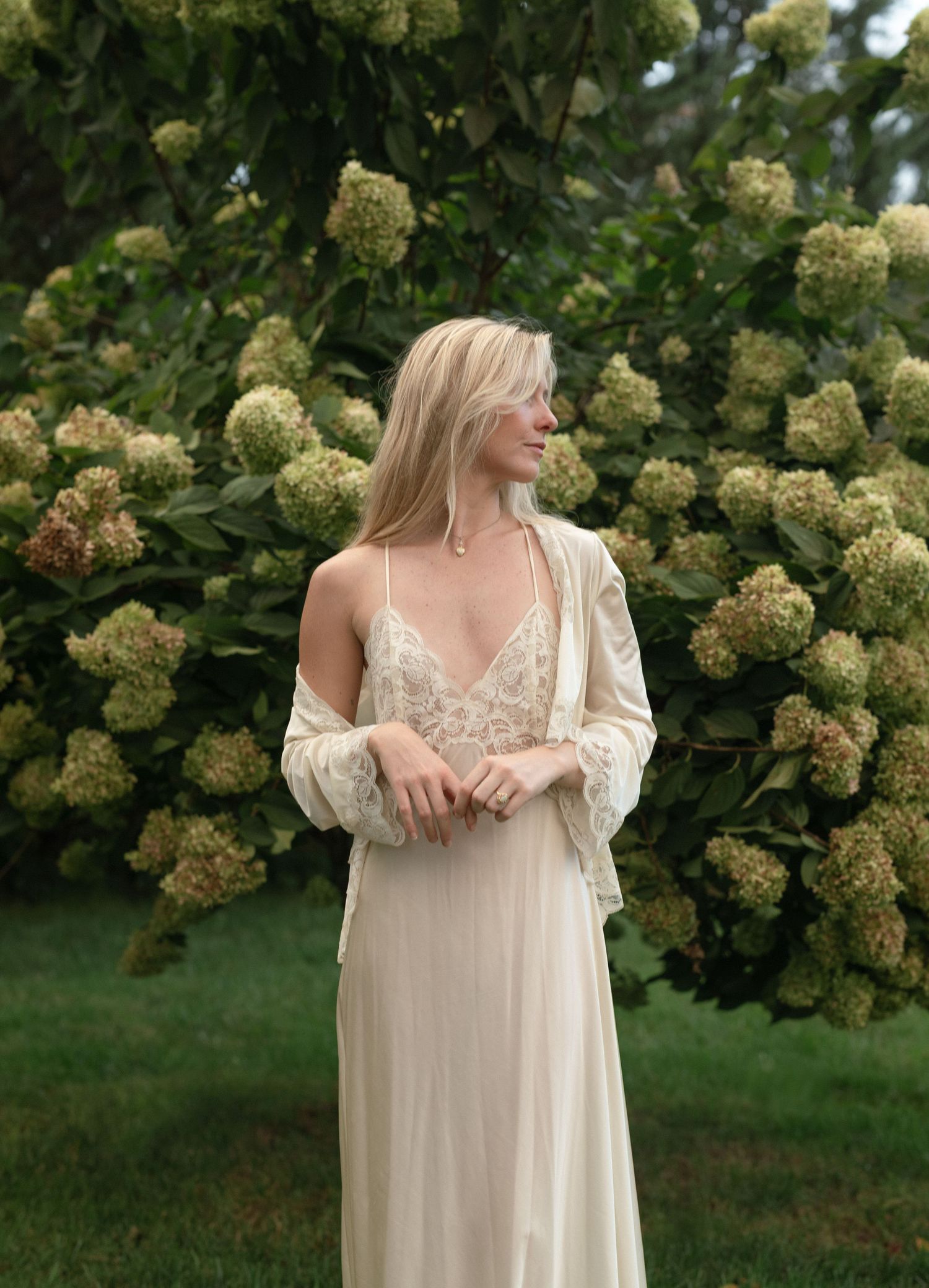 Elegant dress photographed against blooming hydrangea bushes in a garden setting.