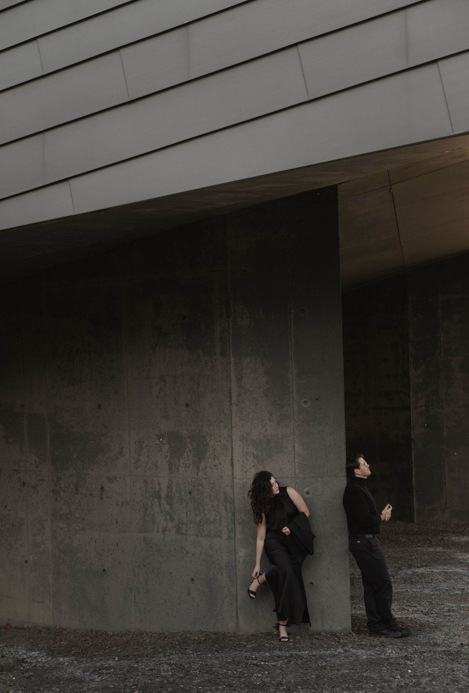 Sequential photos showing dark silhouettes moving against a concrete wall in an artistic performance.