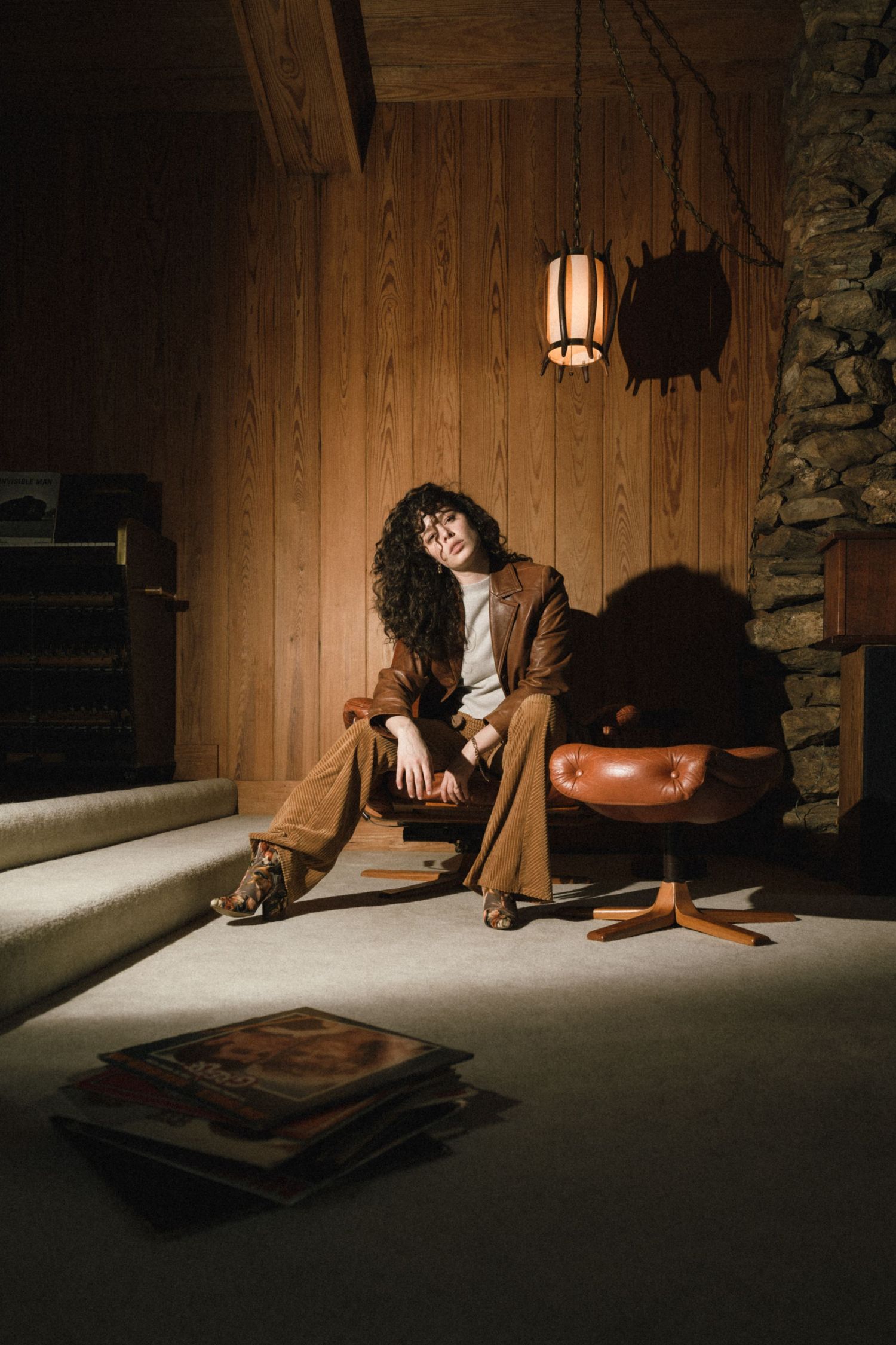 Moody series of photos showing a dimly lit room with wood paneling and dramatic shadows.