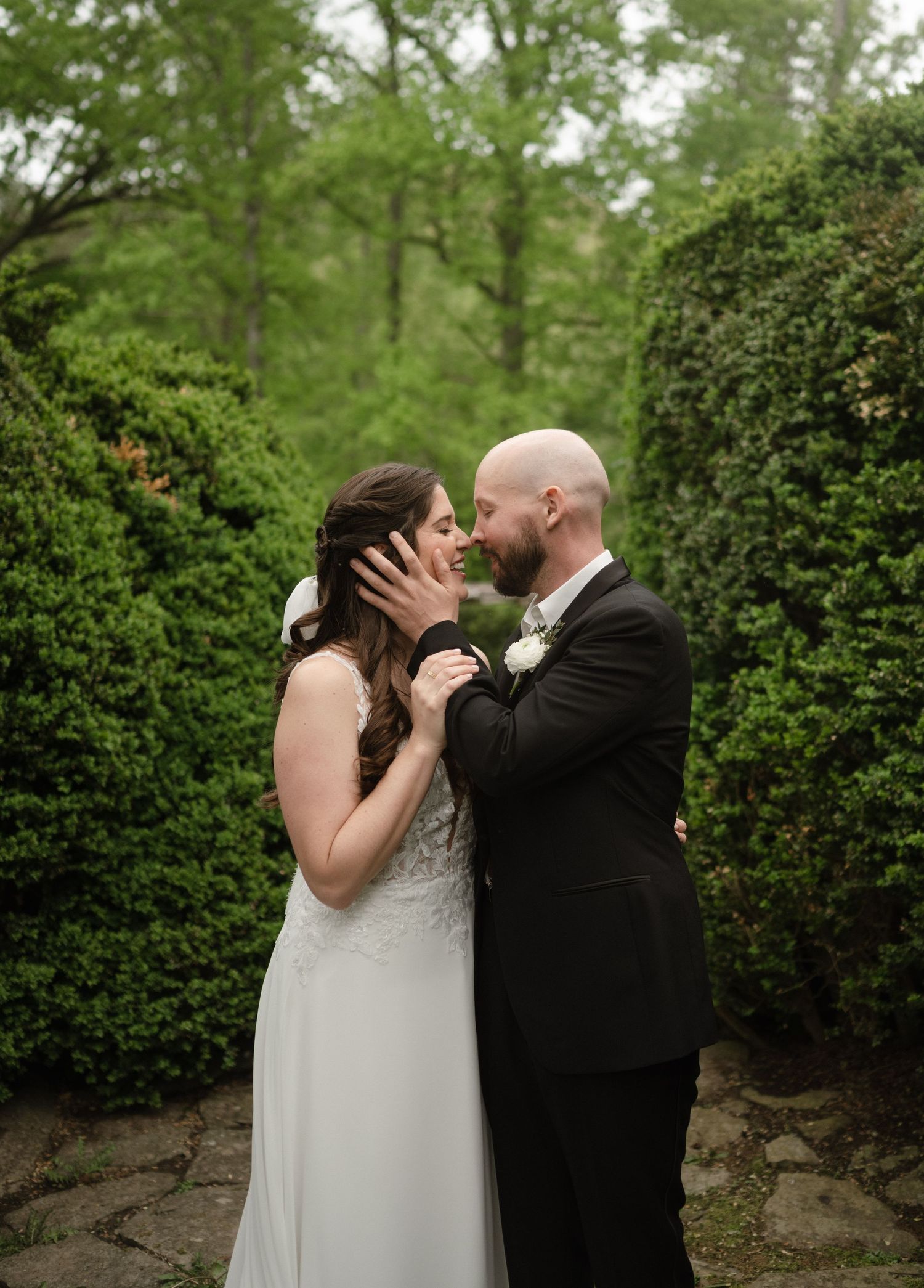 Romantic wedding moment captured in lush garden setting with greenery.