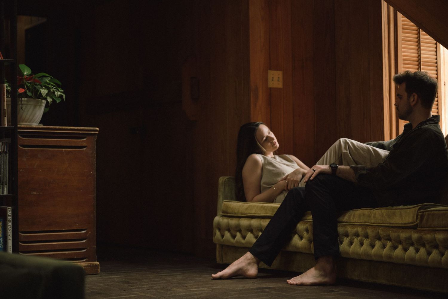 An intimate moment captured in a dimly lit room with vintage furniture.