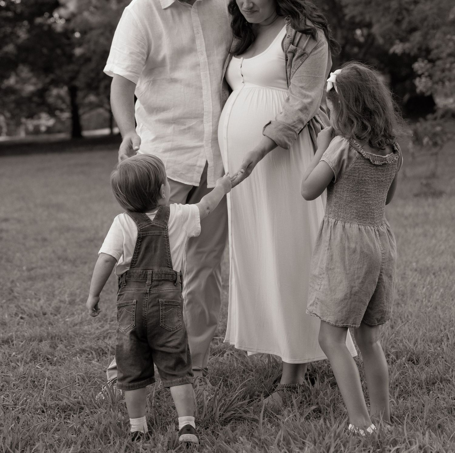 Black and white portrait of a family outdoors showing casual interactions.