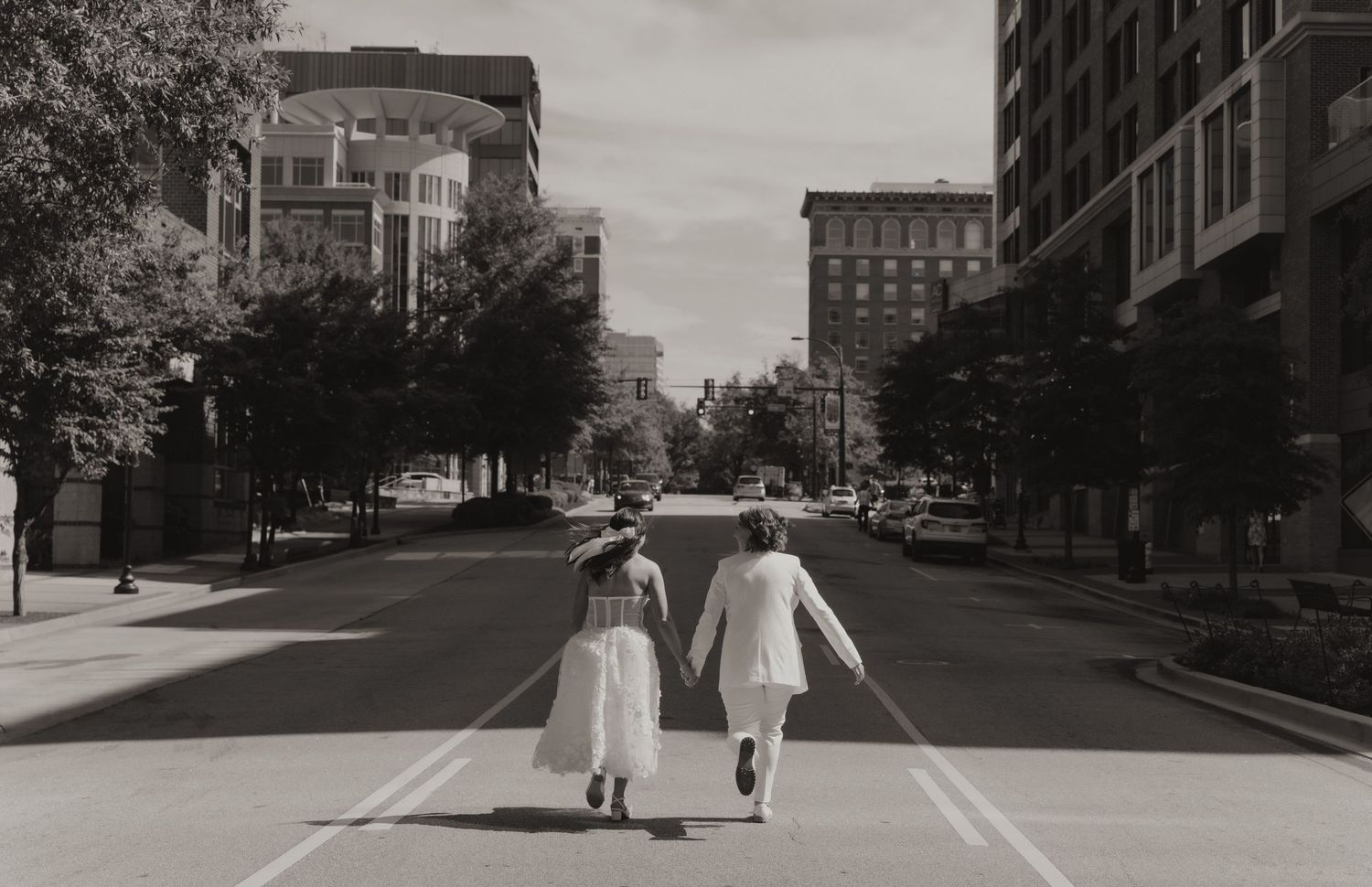 Black and white urban street scene showing buildings and sidewalks in a quiet cityscape.