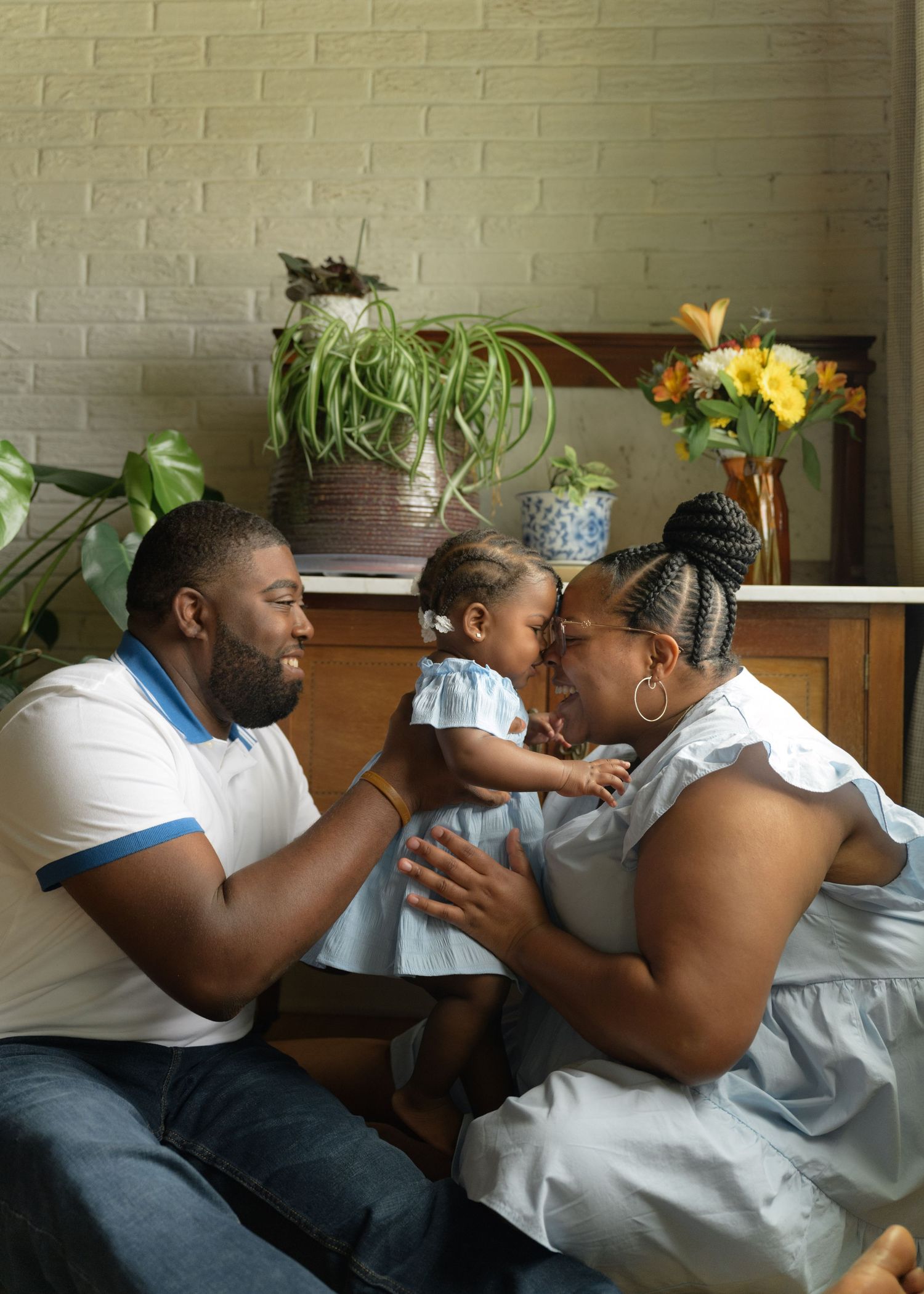 Tender family moment shared between loved ones in a home setting with brick wall background.