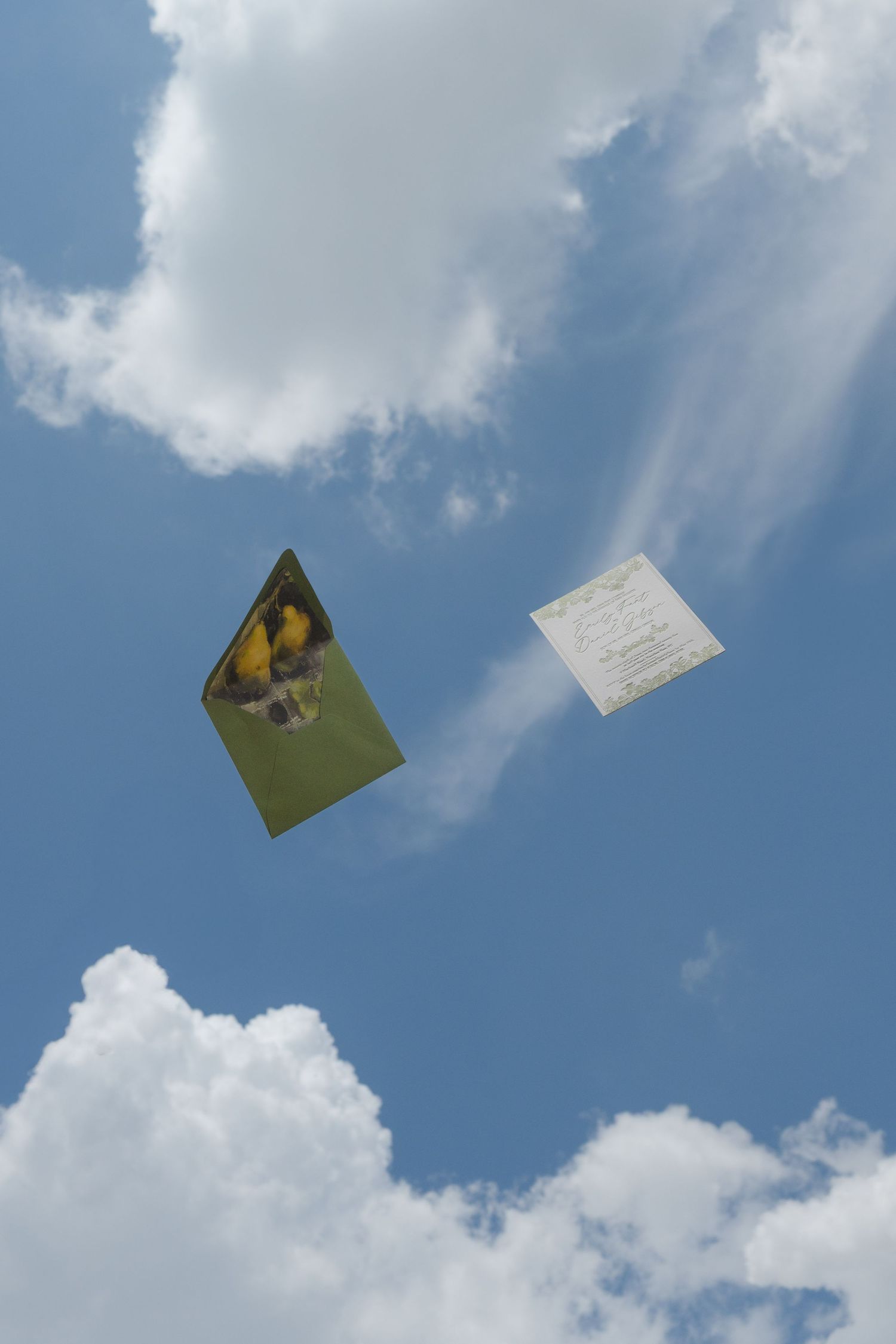 A sequence of an envelope floating against a bright blue sky with white clouds.