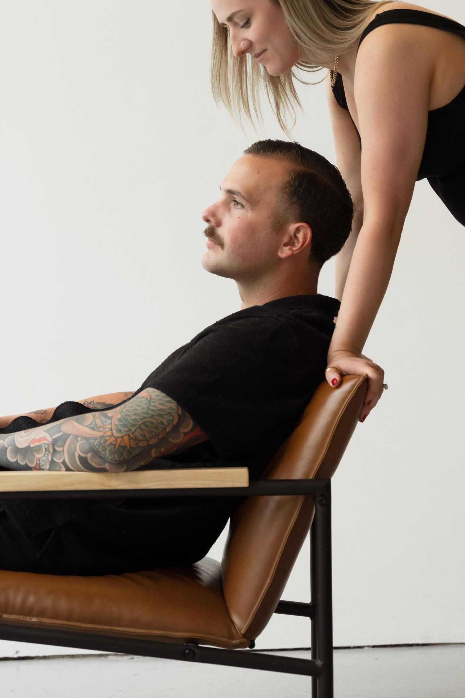 An intimate portrait session with dramatic lighting against a minimal white background.