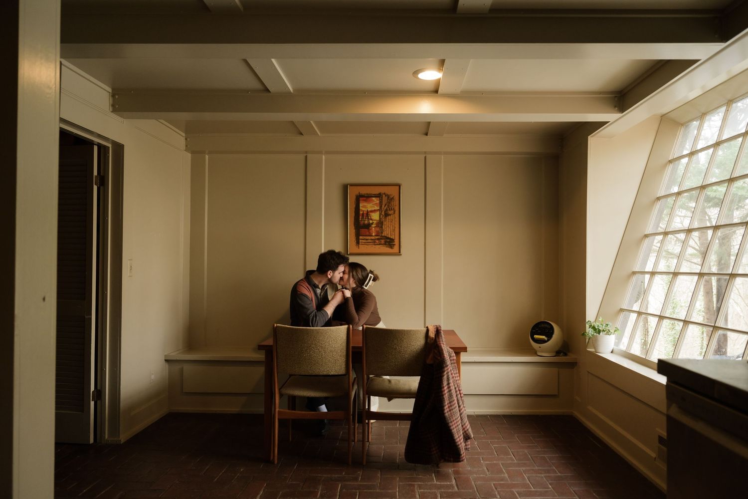 Wide panoramic interior shot of an empty studio room with large windows and wood floors.