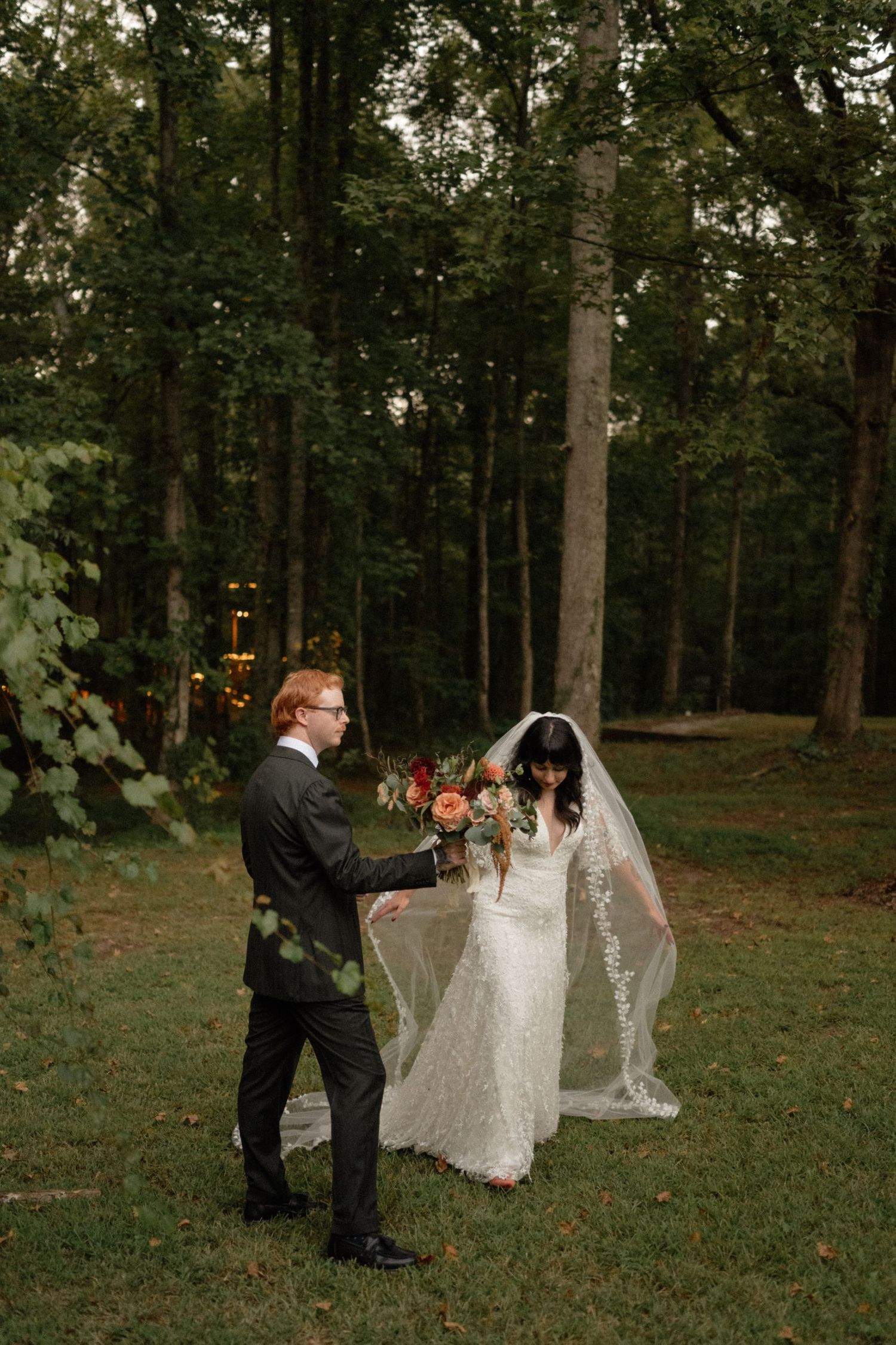 Wedding party gathered in a wooded outdoor setting for photography and celebration.