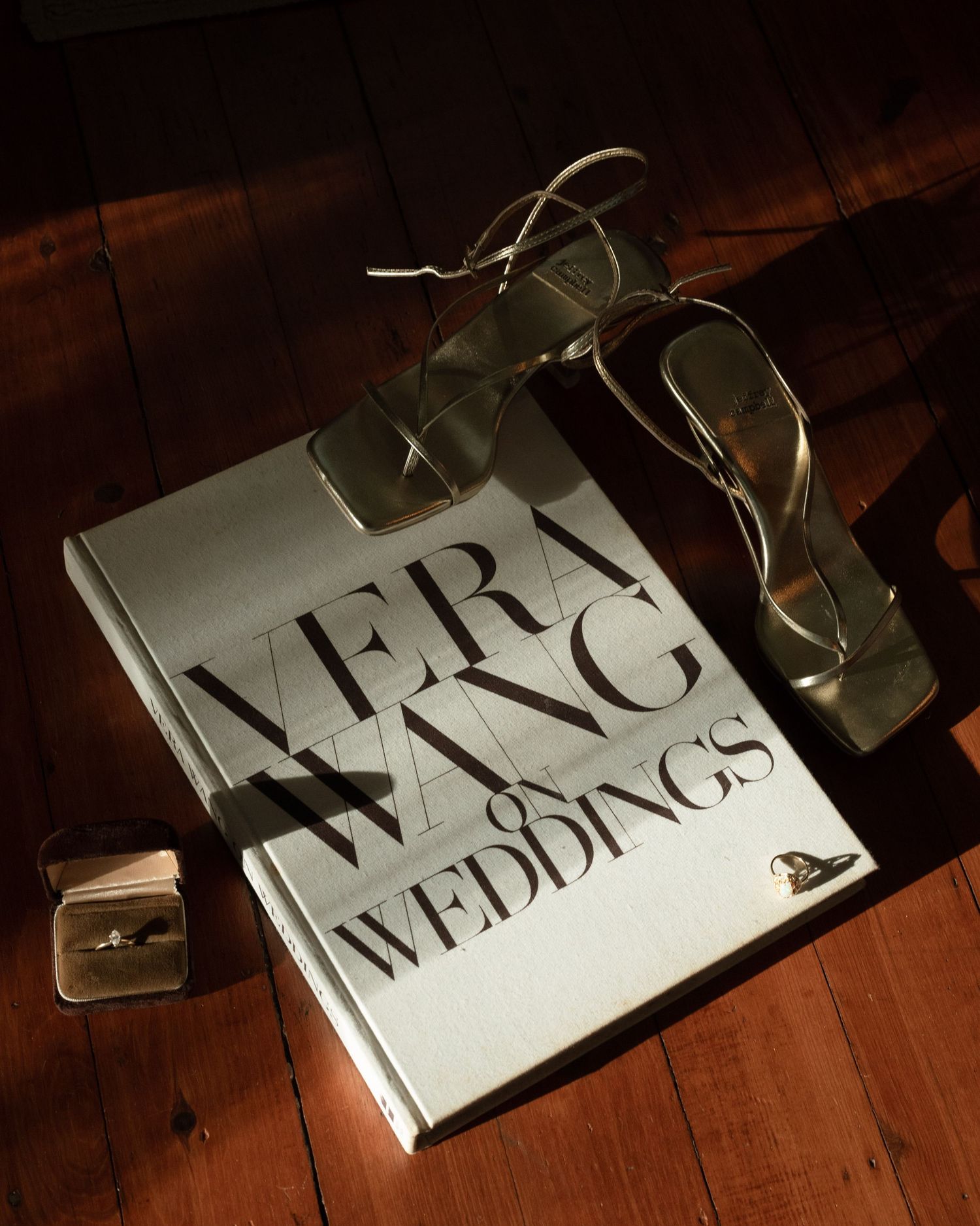 Dramatic lighting sequence of a wedding magazine or publication on wooden surface.