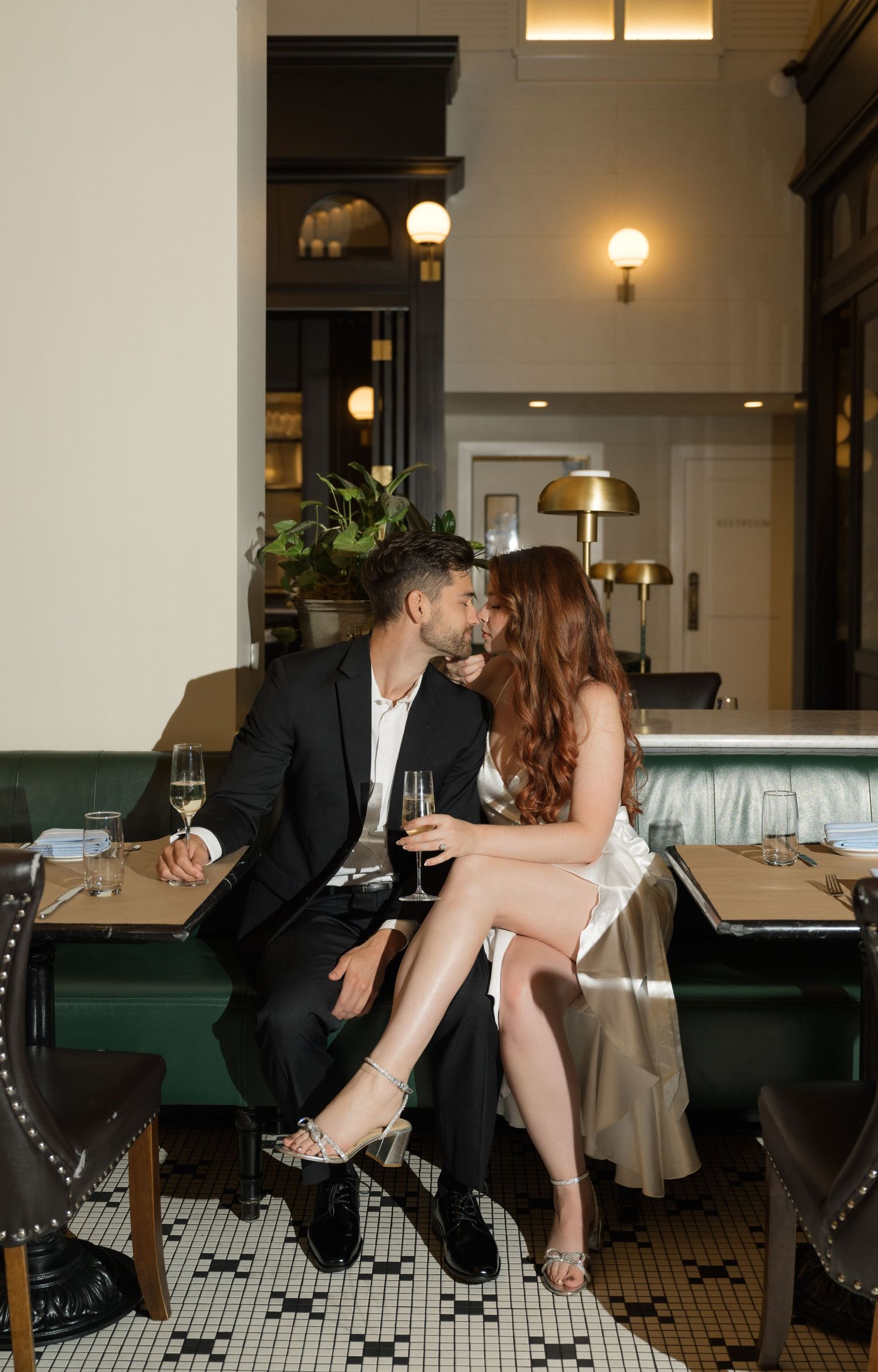 Romantic dance sequence on black and white tiled floor in an elegant restaurant setting.