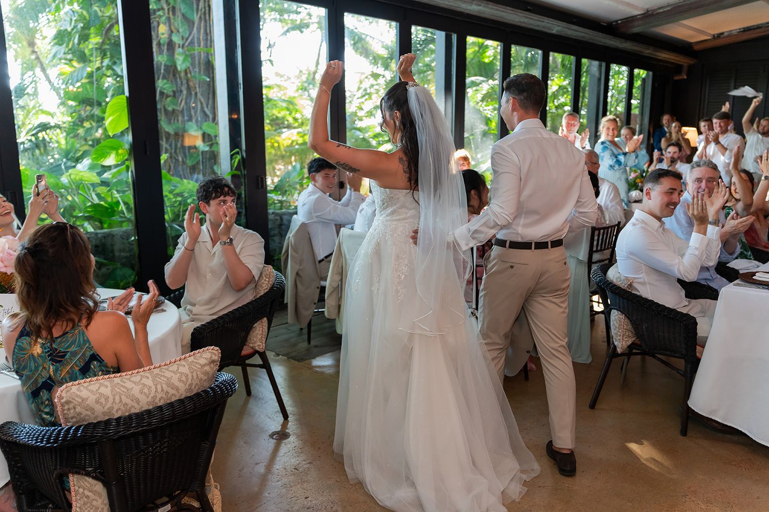 Bride and groom share first dance at elegant outdoor wedding reception with guests applauding.
