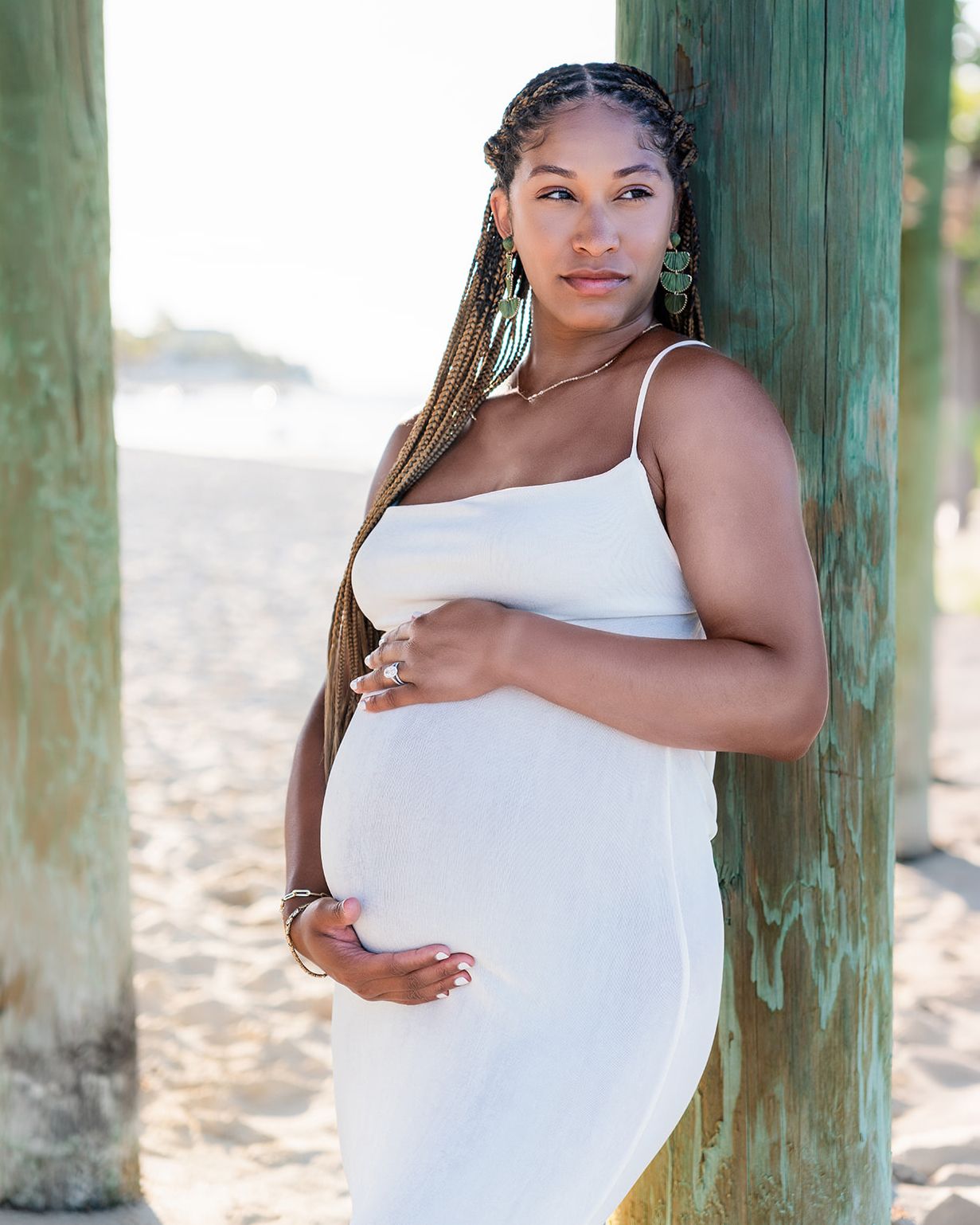Timeless maternity portrait in a white dress on the beach