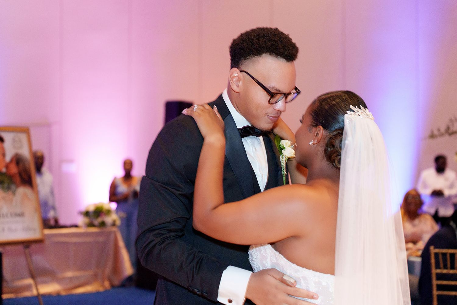 Newlyweds share an intimate kiss during their first dance at a romantic wedding reception.