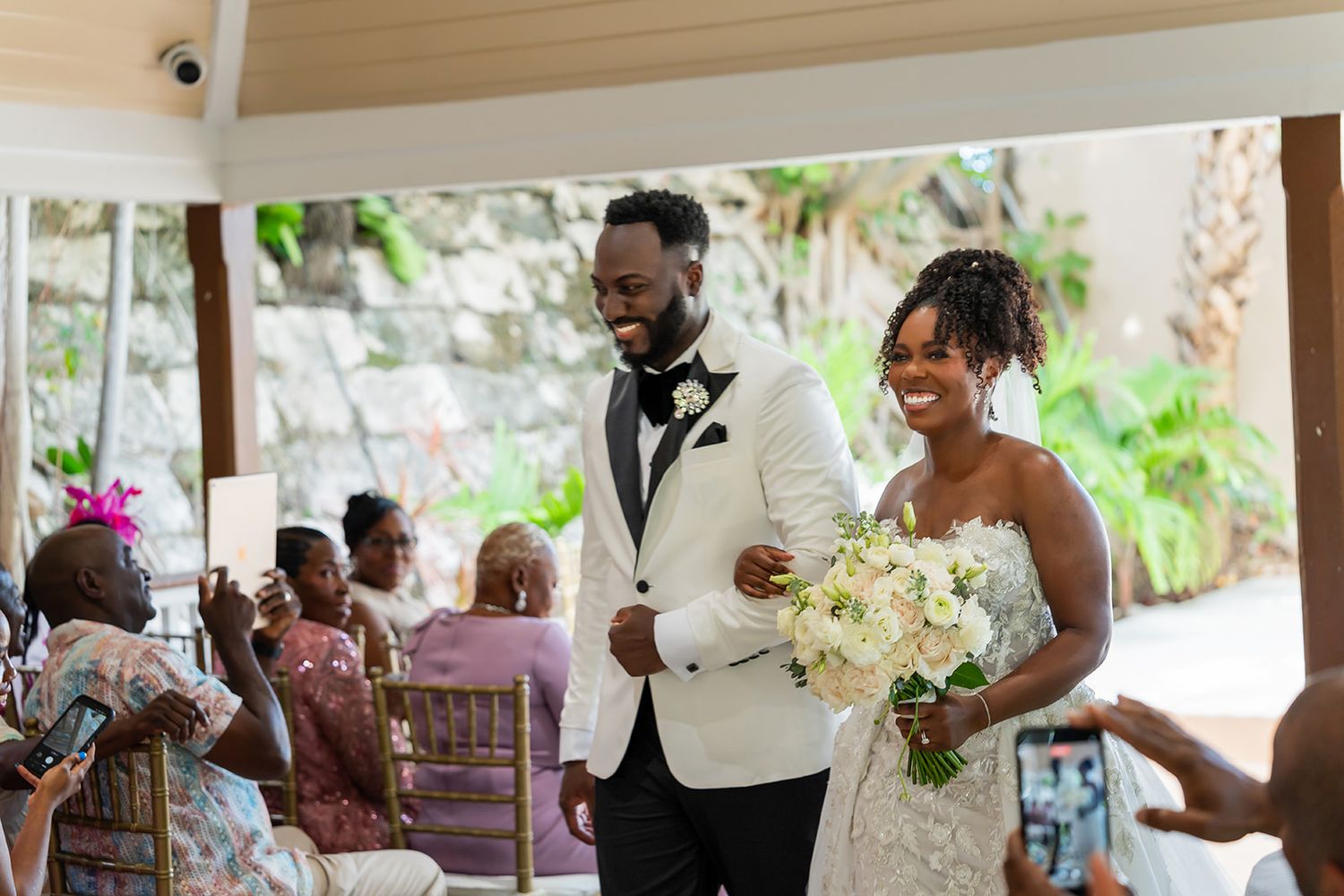 Newlywed couple walks down the aisle smiling after their wedding ceremony.