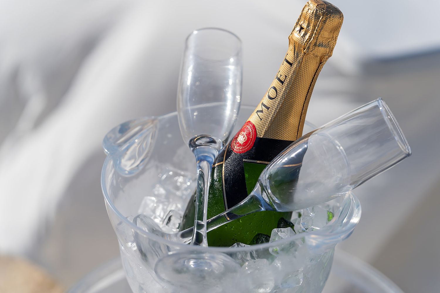 Moet Chandon champagne bottle chilling in ice bucket with crystal flutes at elegant celebration.