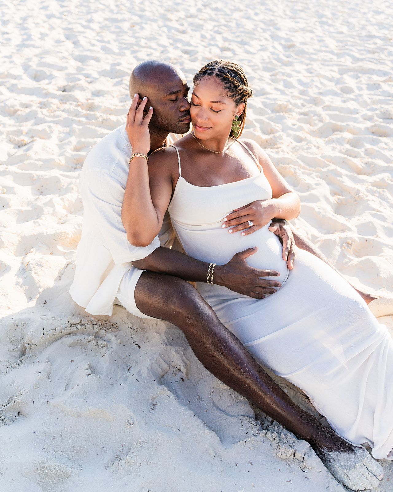 Expecting couple sharing a quiet moment on the beach