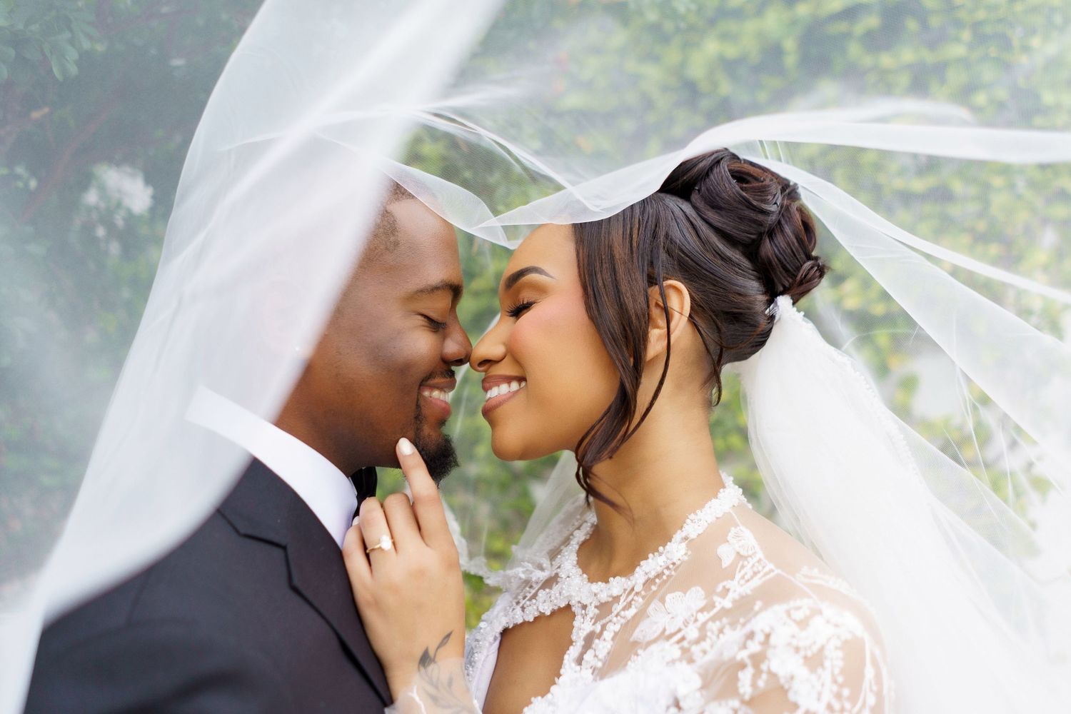 A romantic wedding couple shares tender moments under a flowing white veil in multiple intimate poses.