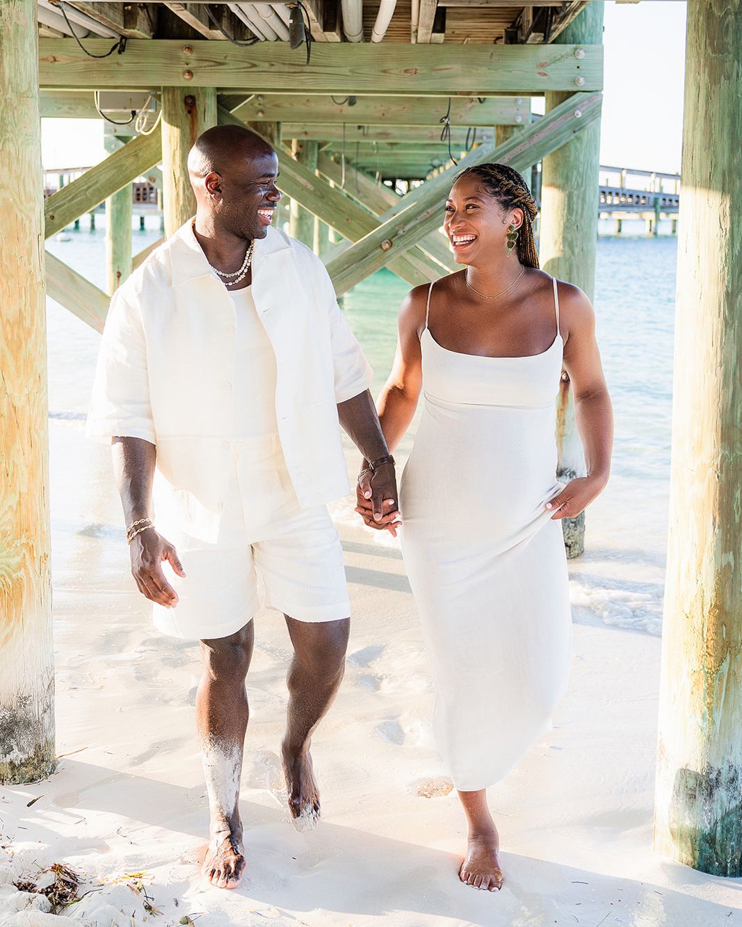 Expecting parents walking together on a Bahamian beach