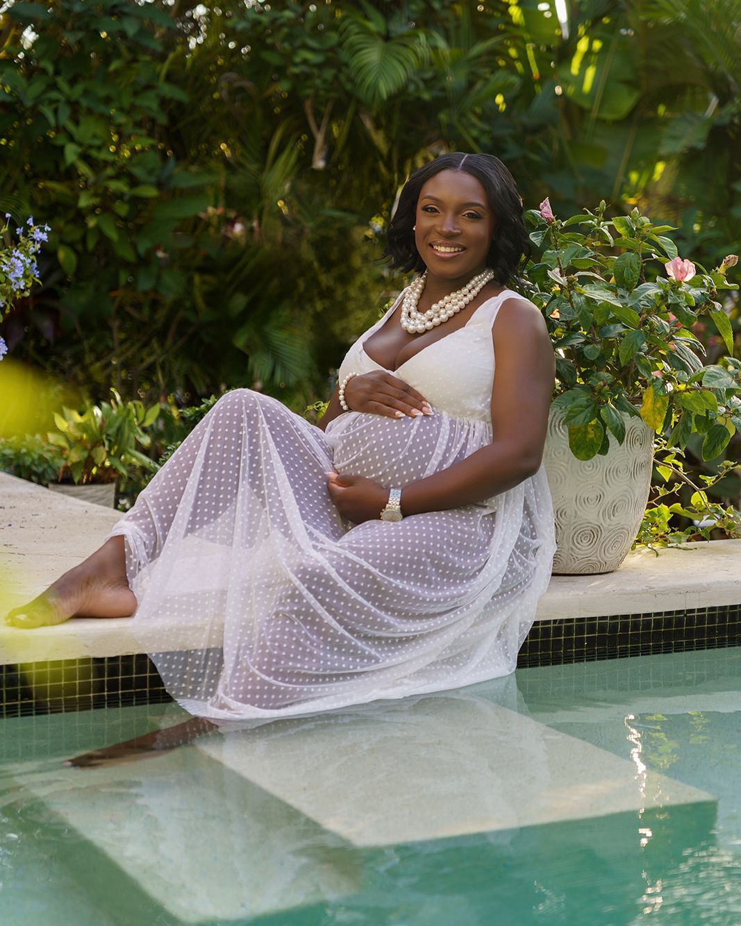 Expecting mother seated beside a tropical swimming pool