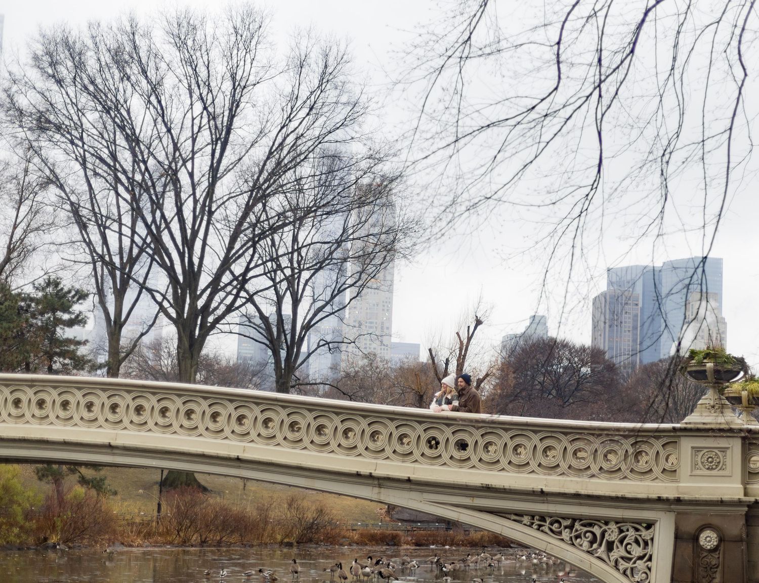 Couple enjoying the view from the Bow Bridge after their proposal