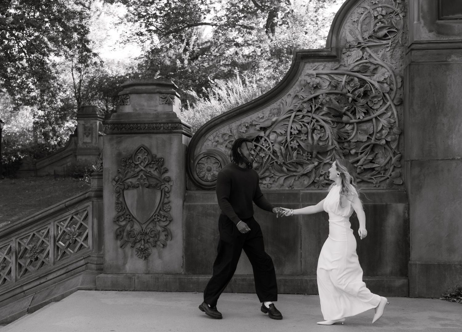 A black and white wedding photo sequence showing a couple dancing playfully on outdoor stone steps.