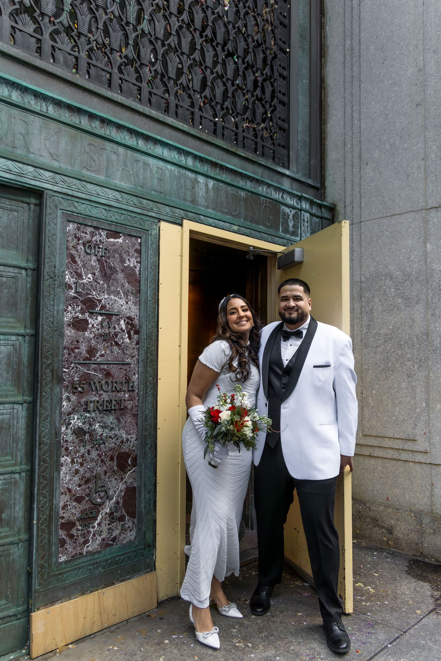 Excited newlyweds walking out of the ceremony room holding a bouquet