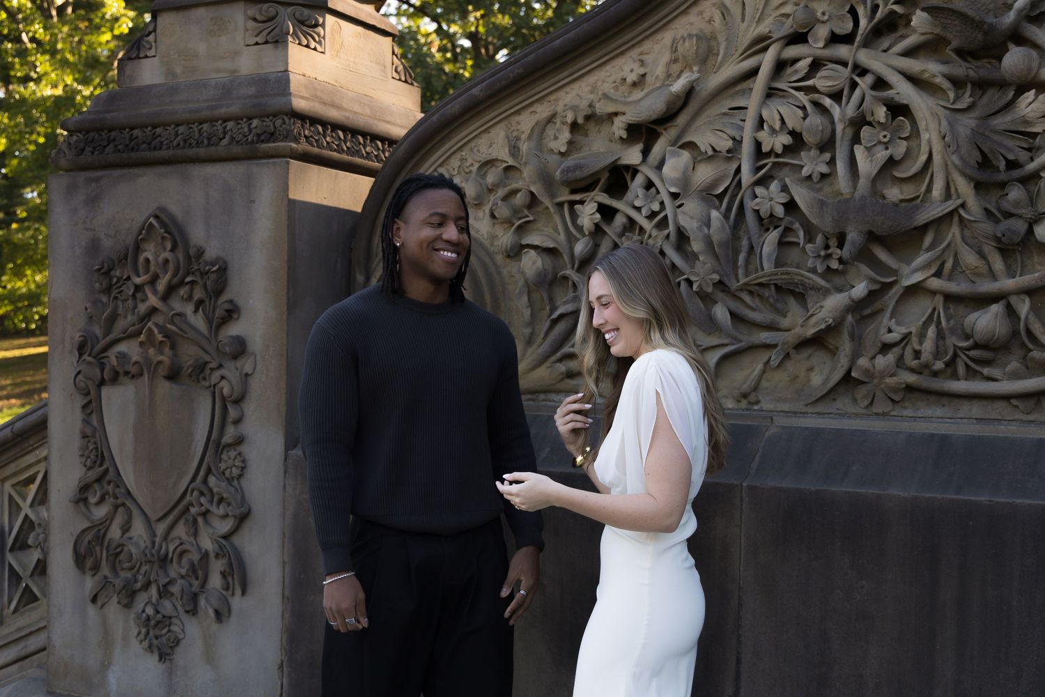 A couple shares a joyful moment together during their photoshoot at Bethesda Terrace.
