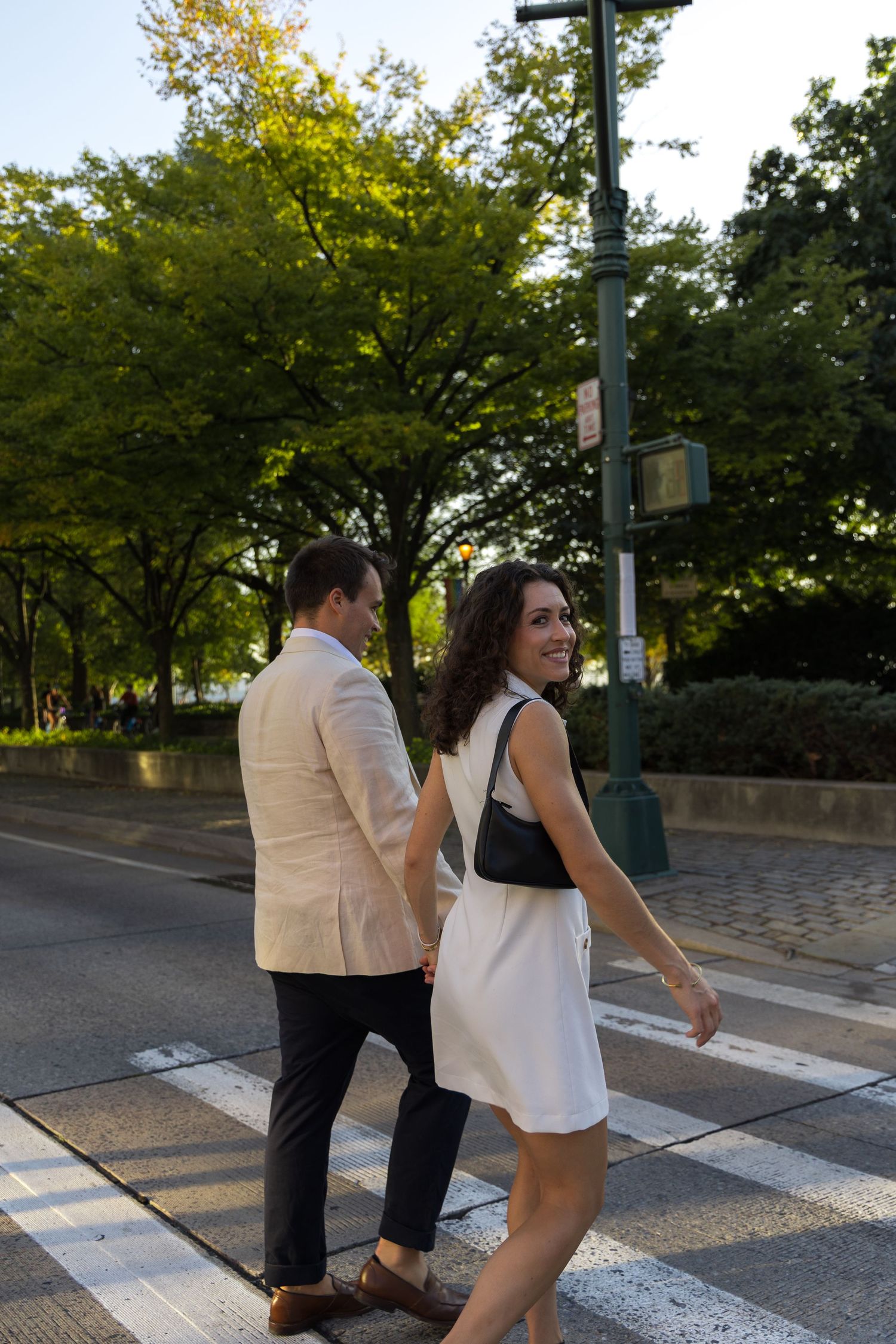 Couple walking across the street in their west village engagement photoshoot in nyc