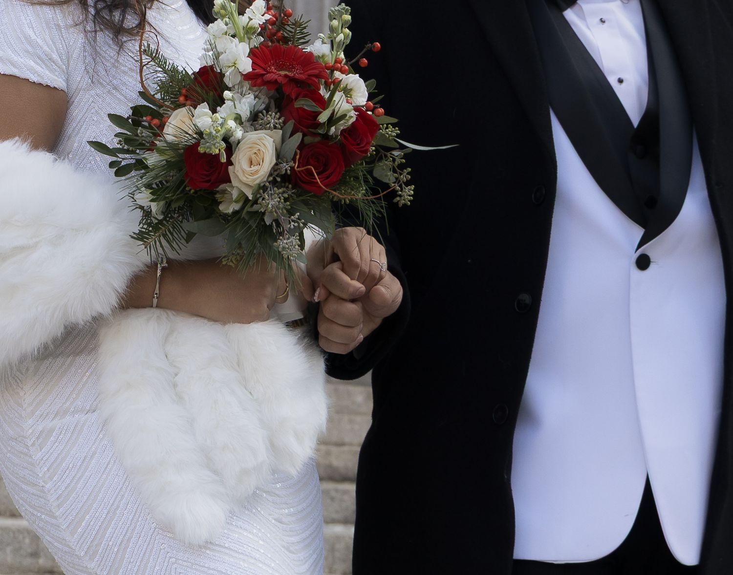 Close up of a newlywed couple holding a bouquet outside the marriage bureau