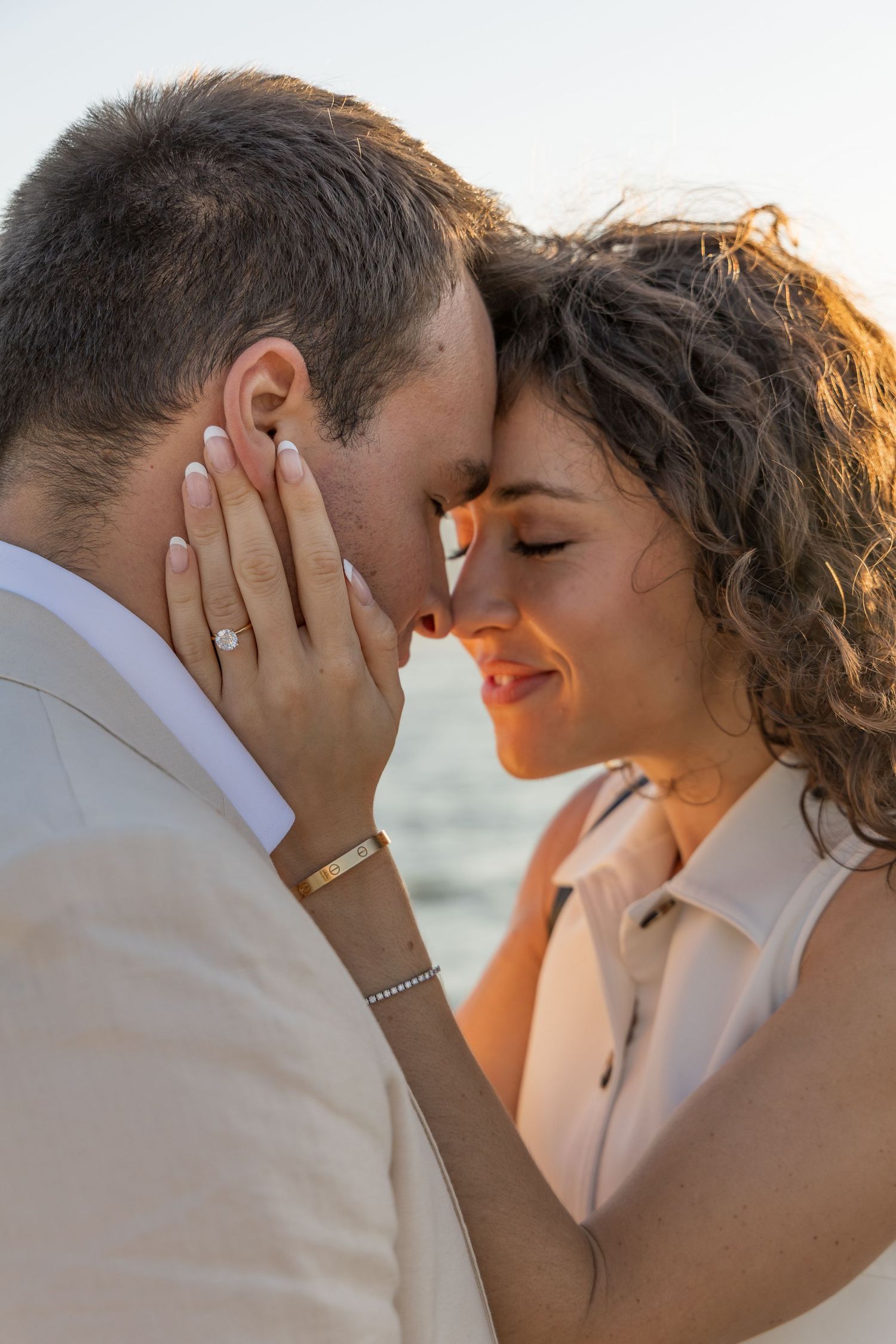 Close up of a couple embracing and holding each others faces during golden hour