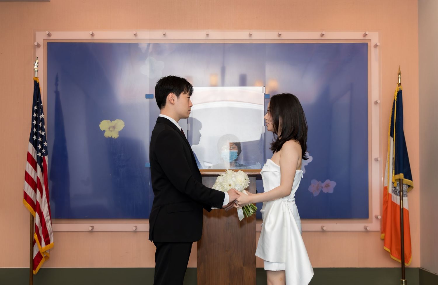 Emotional exchange of vows during a civil ceremony inside the Manhattan Marriage Bureau chapel with the officiant