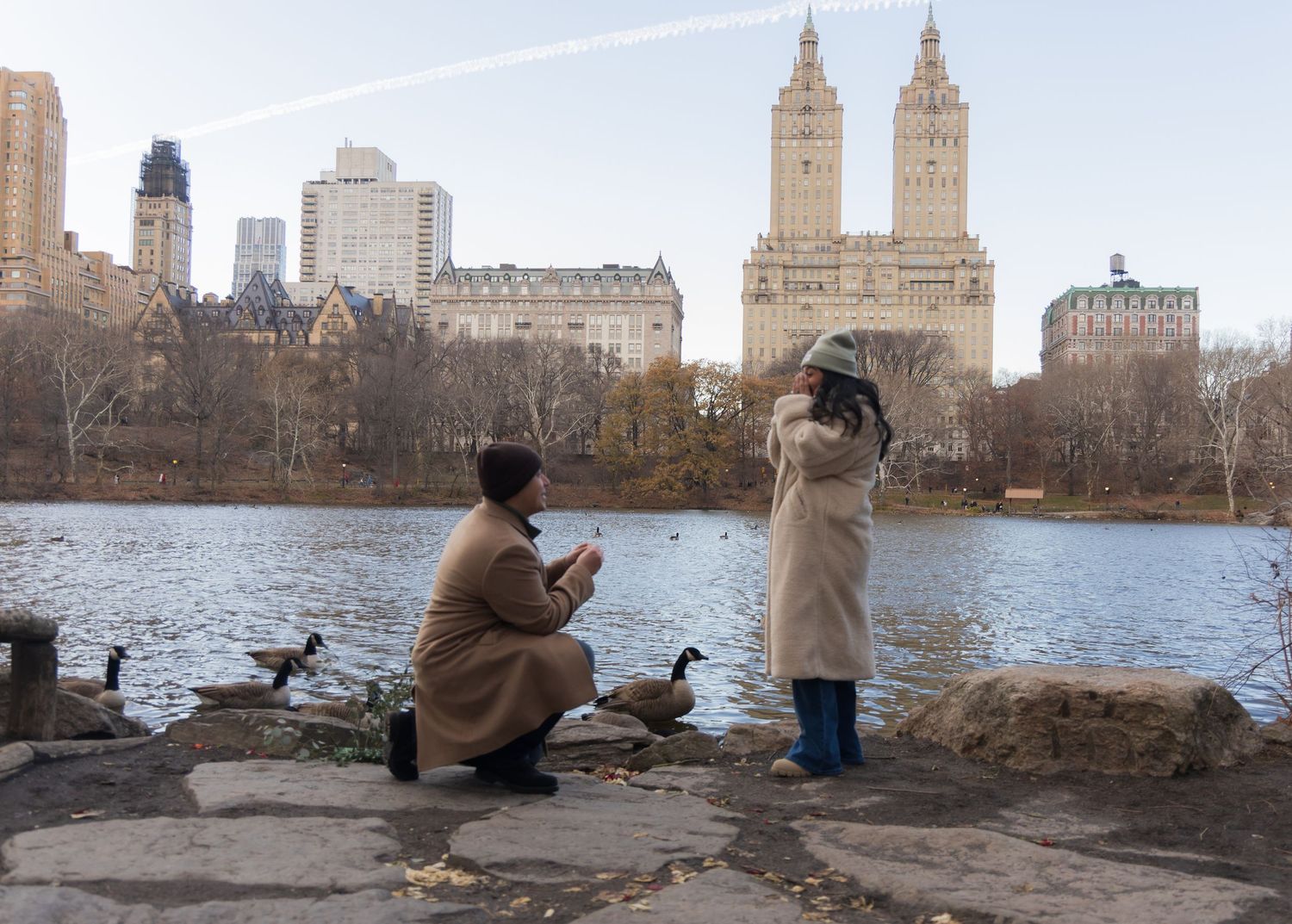 Women getting proposed to by The Lake at Central Park with the San Remo Apartment building in the background