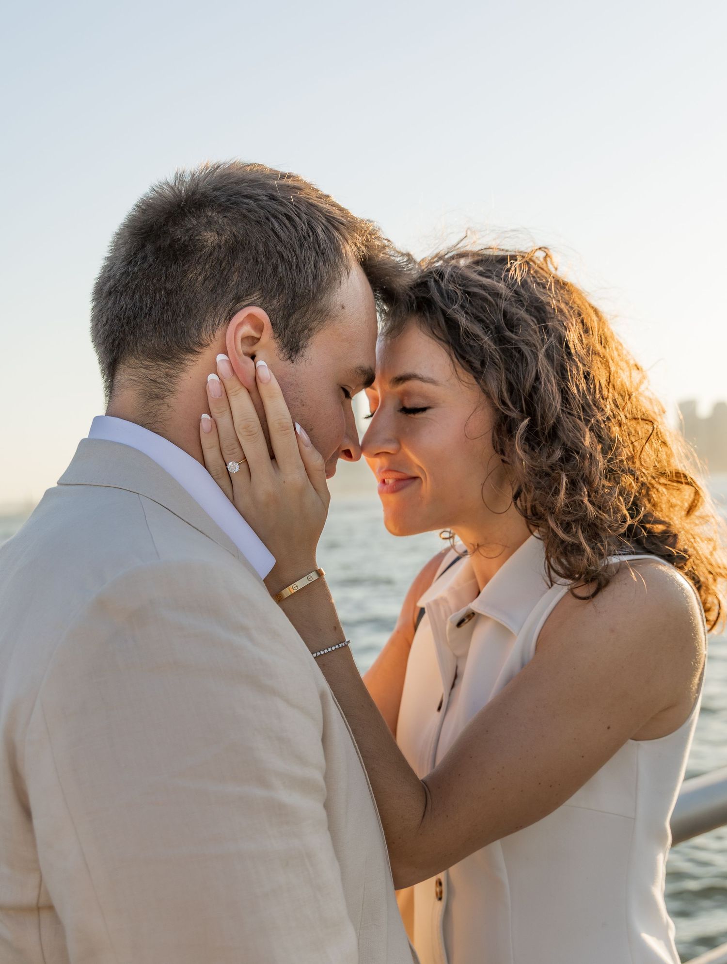 A couple shares an intimate moment at sunset at Pier 45 holding forehead to forehead
