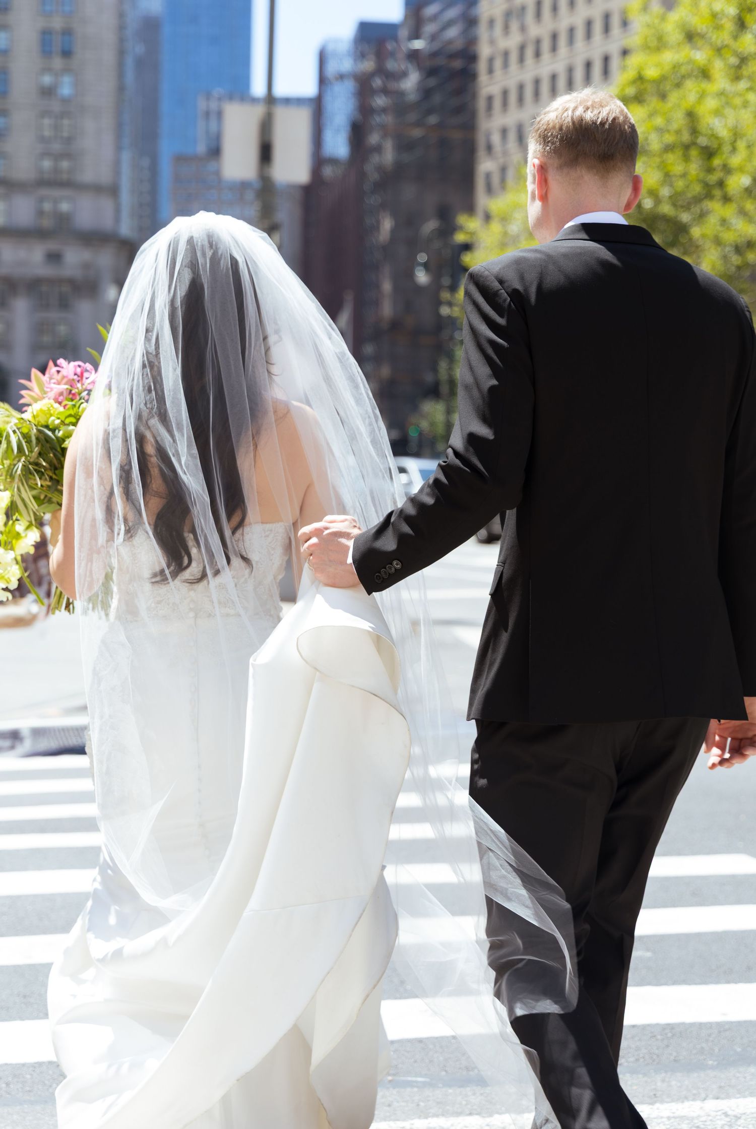Newlyweds crossing the street as a married couple outside the NYC Marriage Bureau