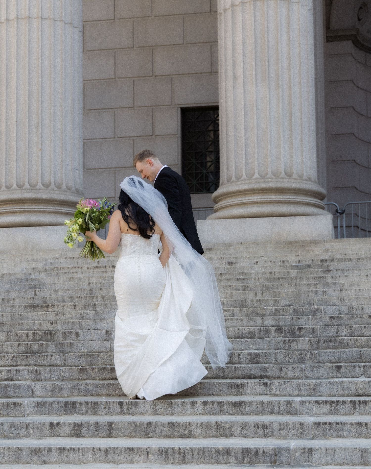Couple walking up the stairs of the NYC Supreme Court after their City Hall Ceremony.
