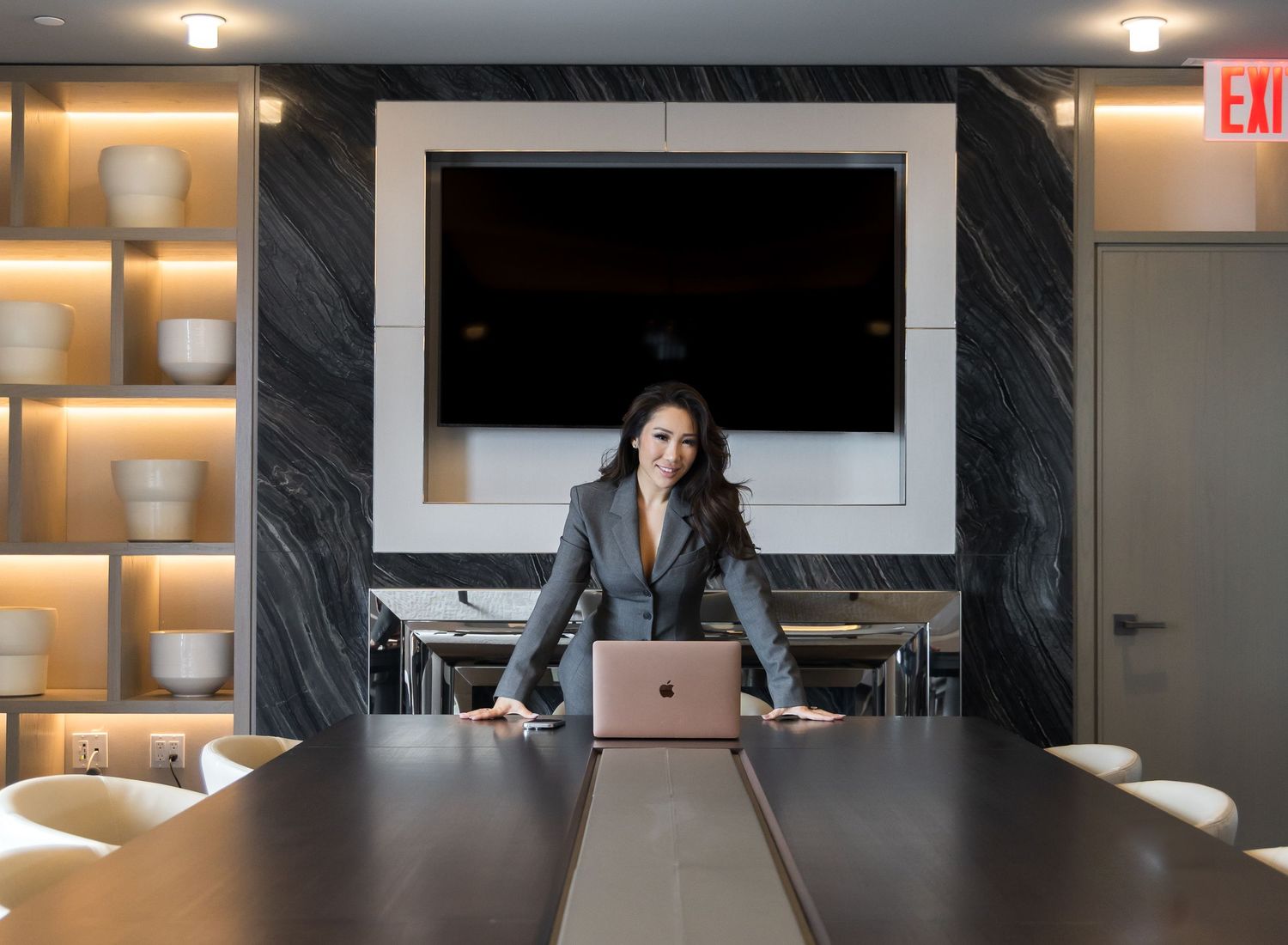 Modern office conference room with glass walls, sleek furniture, and warm lighting creates a professional atmosphere.