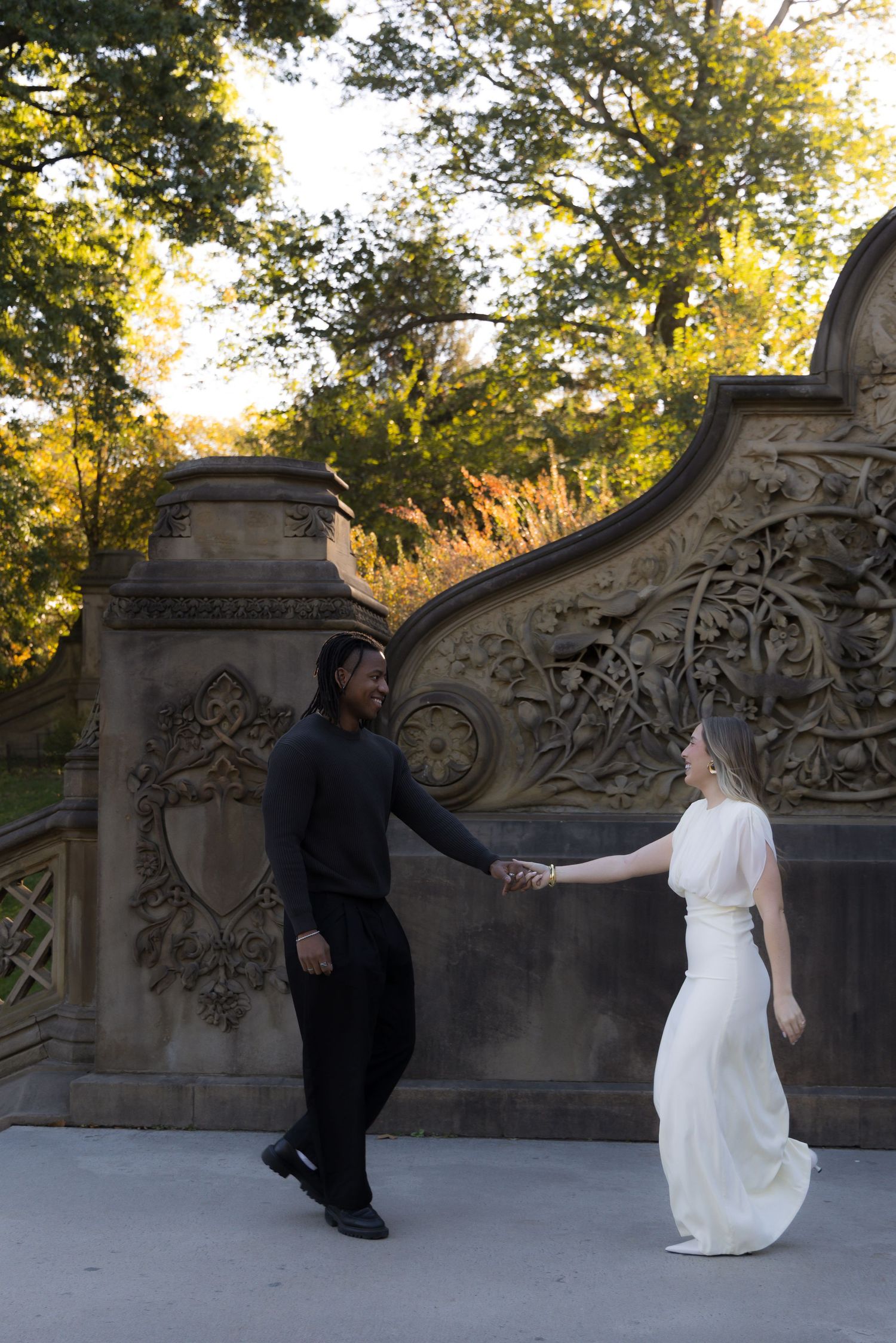 A couple dancing together at sunset near an ornate stone wall in Central Park.