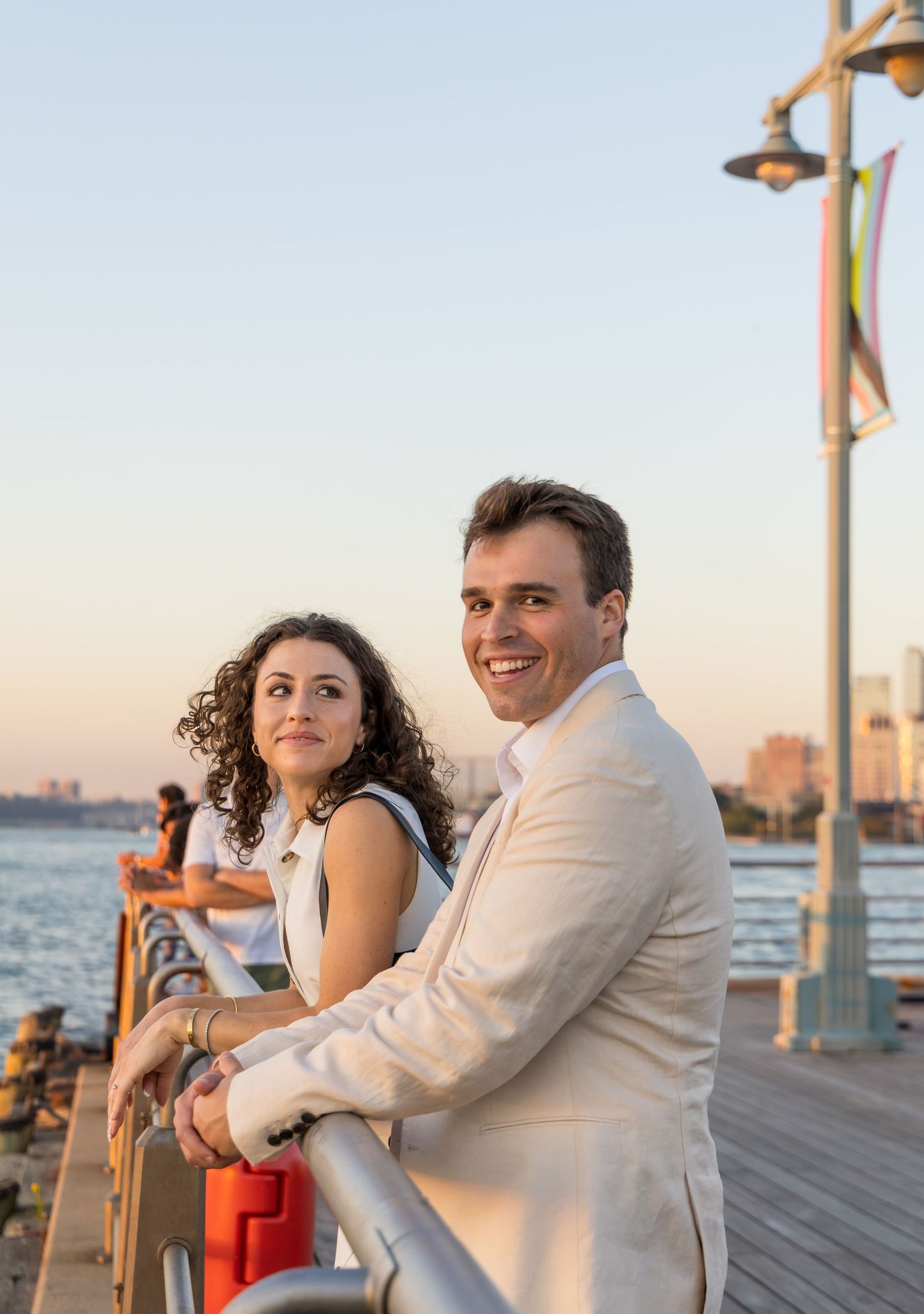Portrait of a women looking at her fiance during golden hour at pier 45 with the nyc skyline in the background
