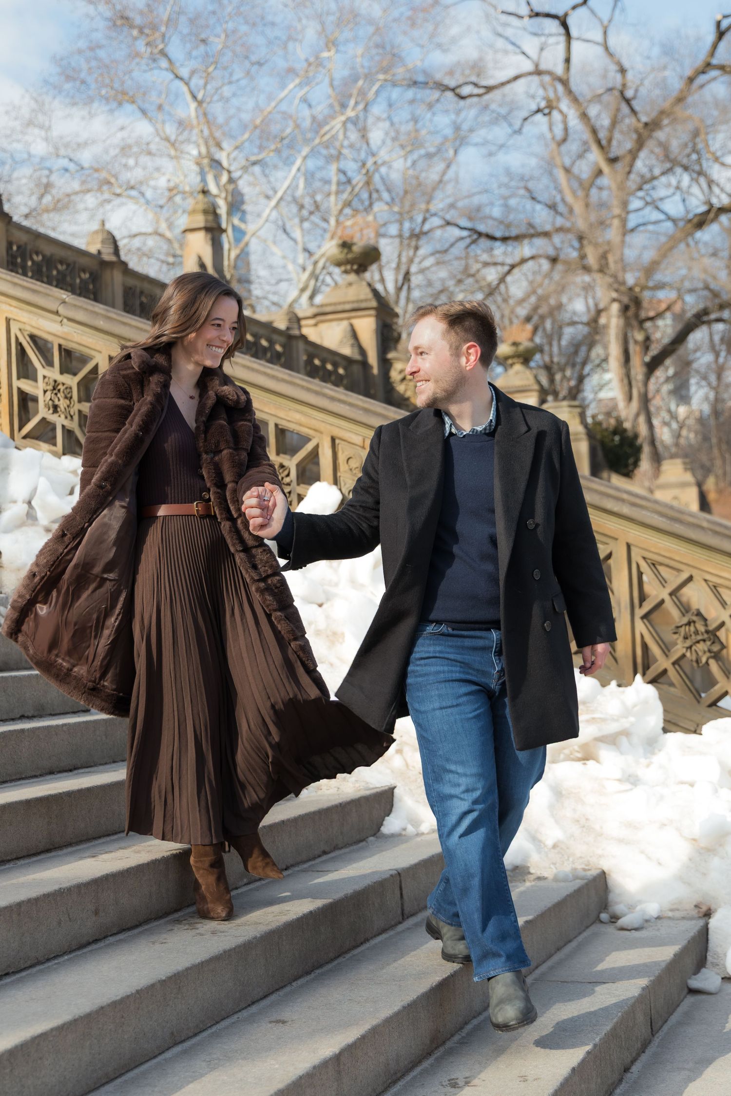 A couple walking down the steps of the Bethesda Arcade in Central Park.