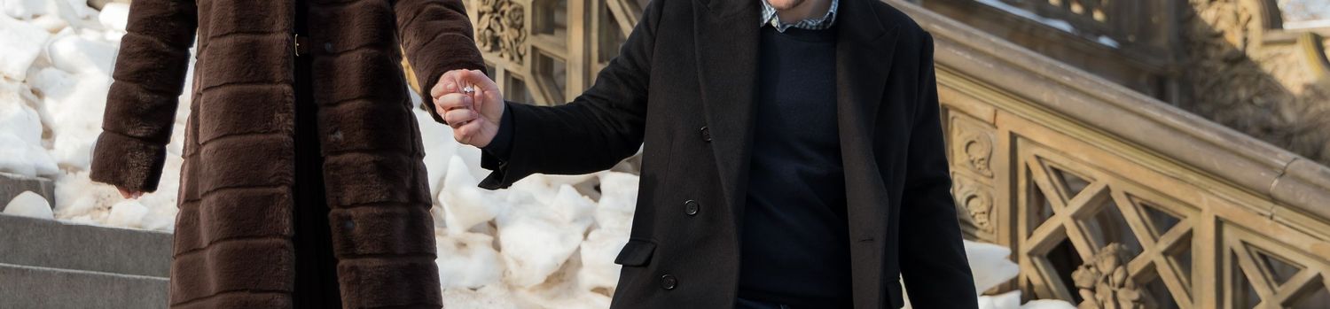 A close up of a newly-engaged couple's hands holding as they walk down the steps of Bethesda Arcade.