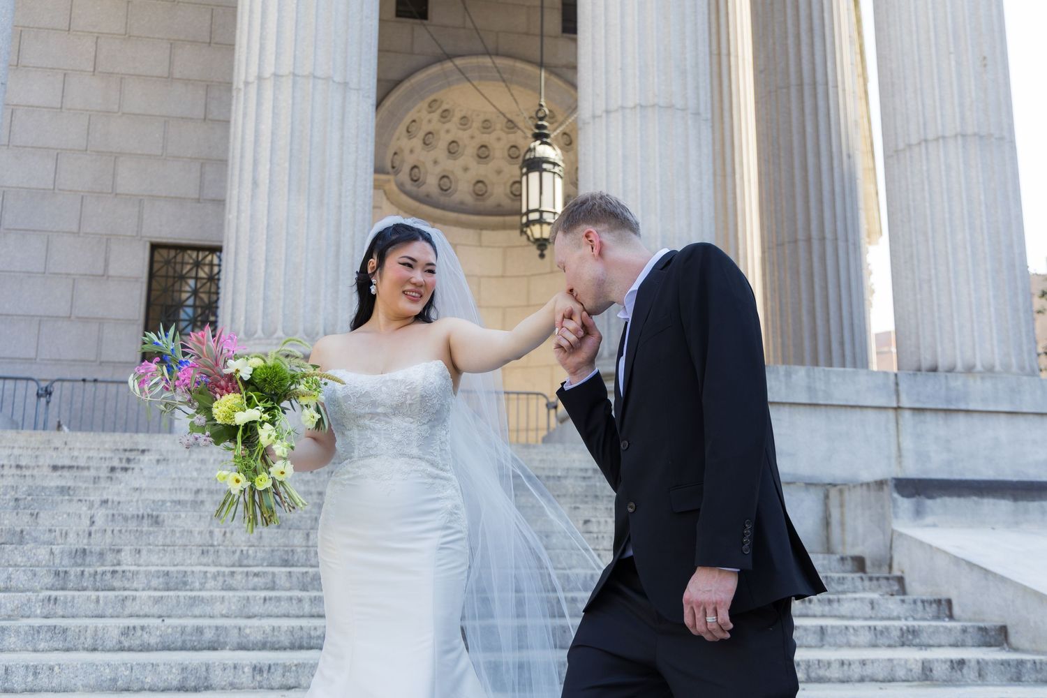 Couple on the steps of the Supreme Court after their NYC marriage ceremony taking portraits