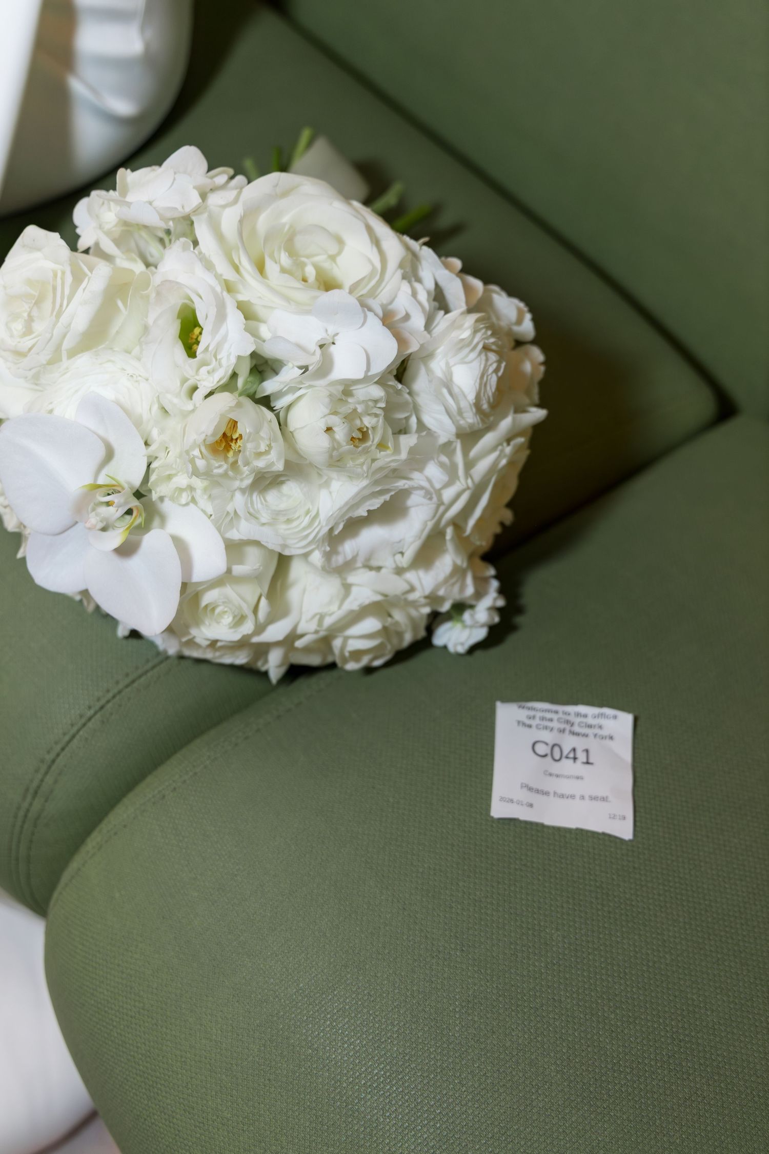 Close up of the wedding ticket number and a white bouquet of flowers