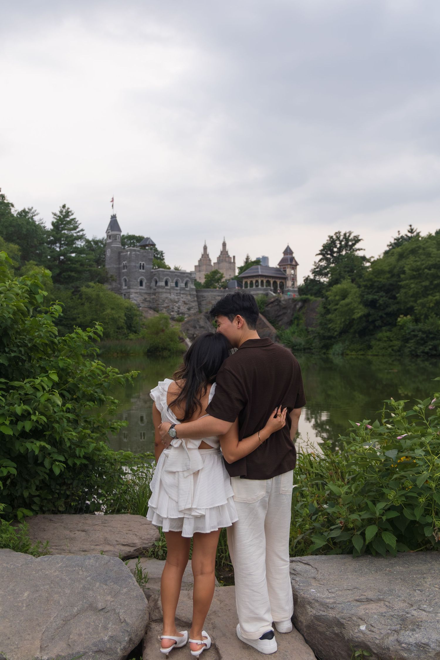 Couple embracing while overlooking Belvedere Castle and pond in Central Park, New York City.